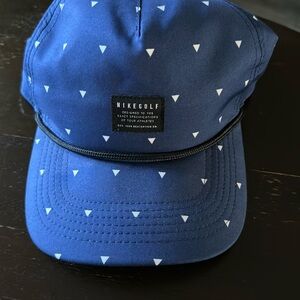 Never worn Nike Golf blue hat with white triangles black rope adjustable hat